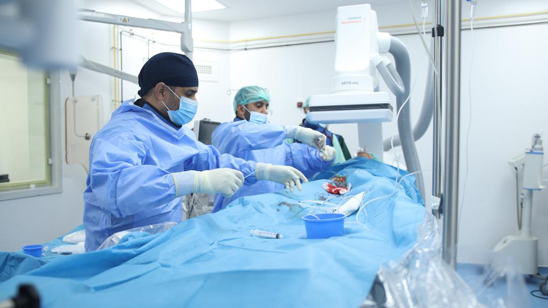 Des médecins réalisent une intervention dans une salle de cathétérisme