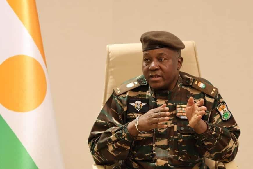 Le général Abdourahamane Tiani en tenue militaire devant le drapeau nigérien