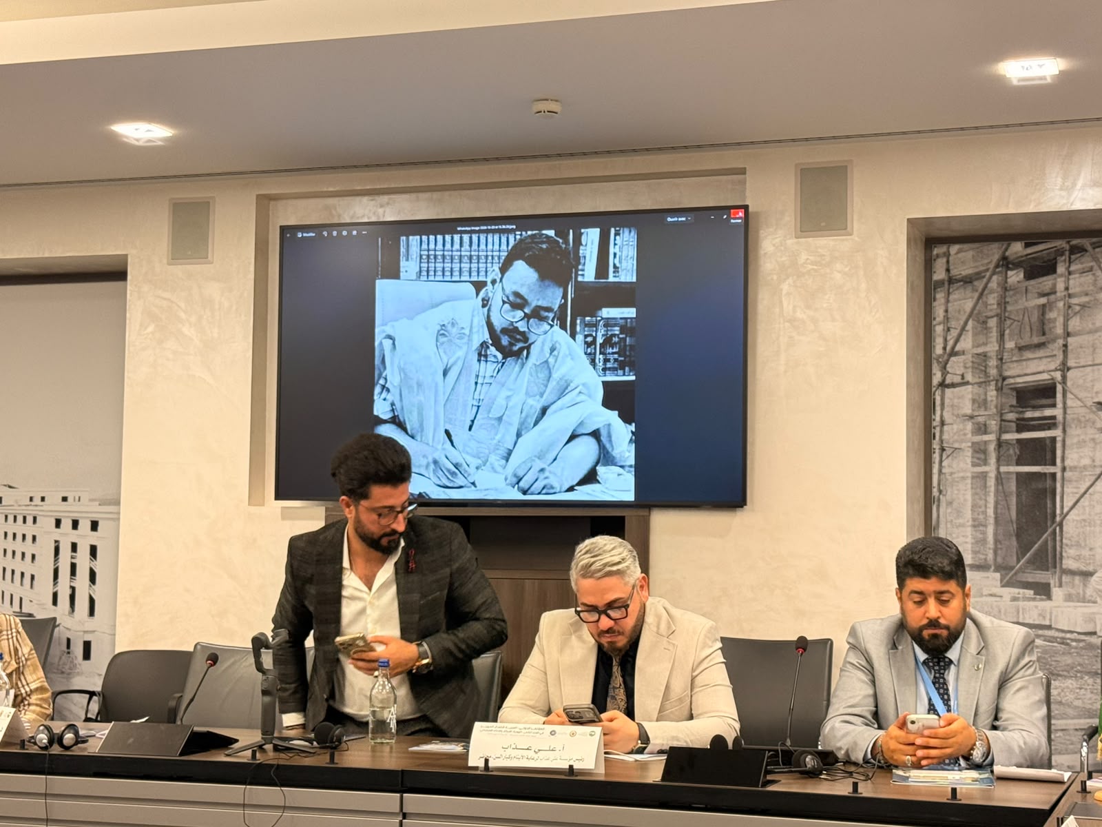 Une photo du défunt universitaire projetée sur un écran lors d'une séance de la conférence à Genève