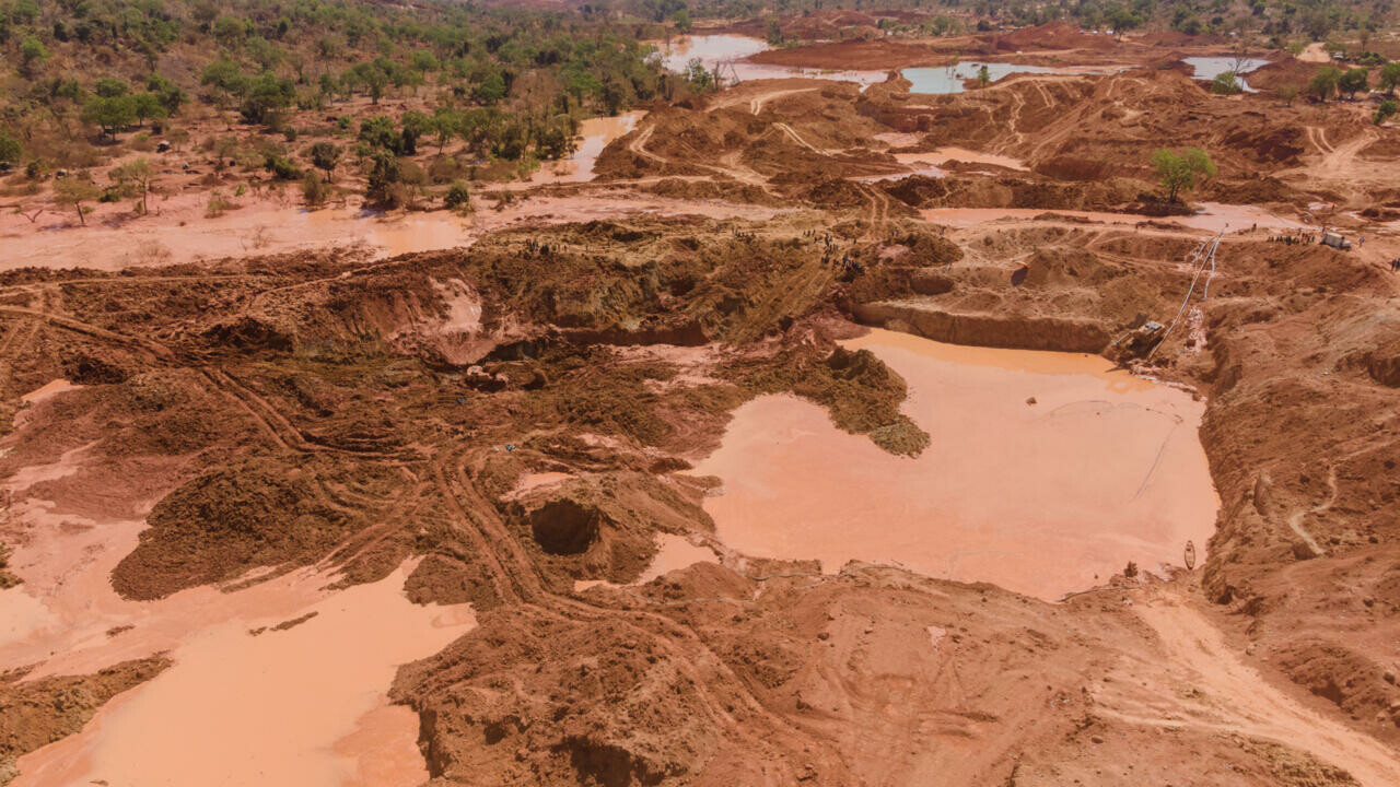 Vue aérienne d'un site d'extraction d'or avec des fosses et des bassins d'eau boueuse sur une terre rouge, photo d'archives