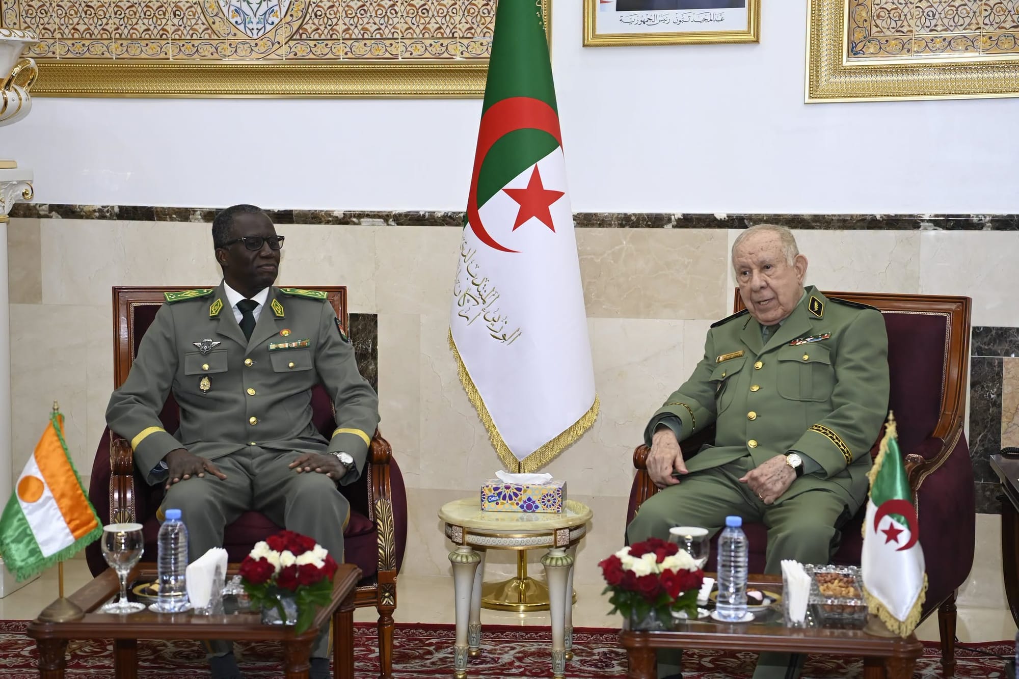 Le chef d'état-major de l'armée algérienne assis aux côtés d'un général nigérien, les drapeaux des deux pays devant eux