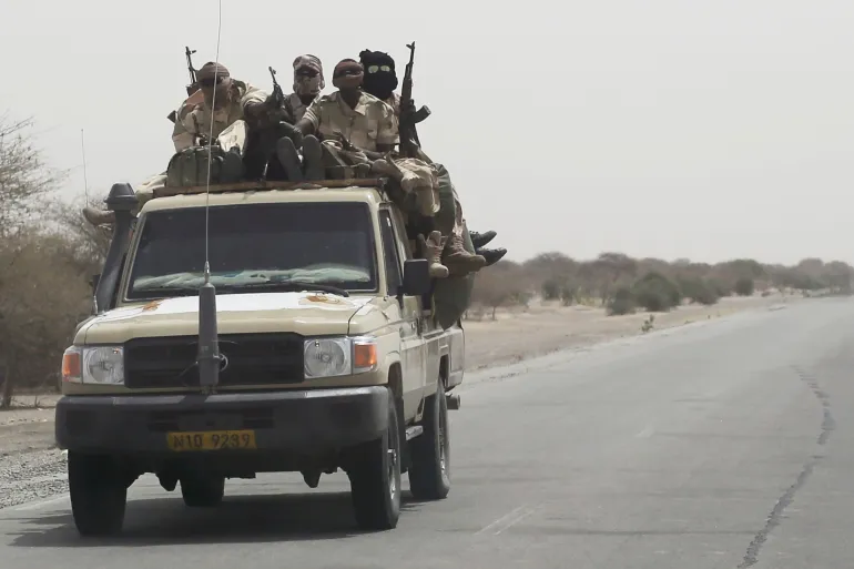 Des militaires armés à bord d'un pick-up sur une route désertique, photo d'archives
