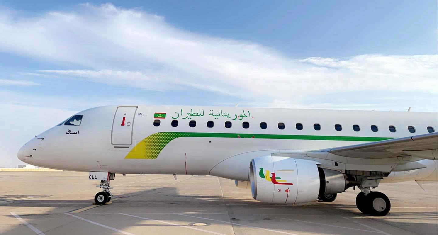 Un avion blanc aux couleurs de Mauritania Airlines sur le tarmac d'un aéroport